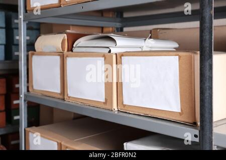 Cardboard boxes with documents on shelving unit in archive Stock Photo