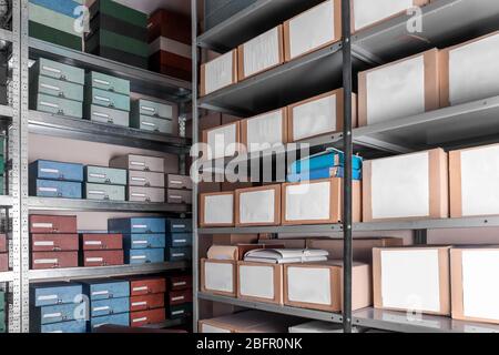 Cardboard boxes with documents on shelving units in archive Stock Photo