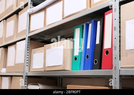 Cardboard boxes with documents on shelving unit in archive Stock Photo