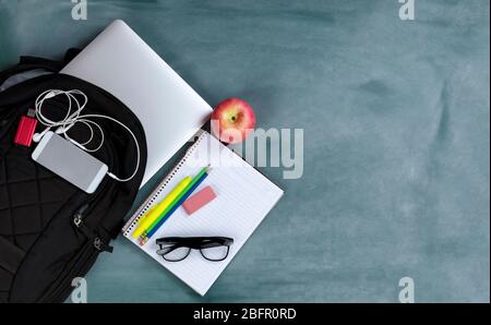 Back to school concept with basic modern technology and traditional educational objects on erased green chalkboard background Stock Photo