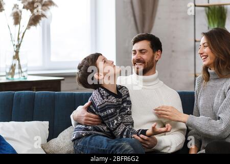 Portrait of smiling father, mother and son. Happy family spending time together at home. Cute boy with mom and dad playing at home. Time to family Stock Photo