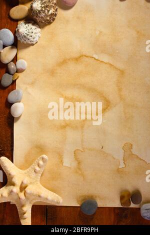 old paper, starfish and stones on wooden table Stock Photo