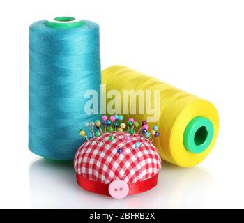 Bobbins of thread with colored pinheads in pin-cushion isolated on white Stock Photo