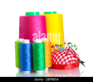 Bobbins of thread with colored pinheads in pin-cushion isolated on white Stock Photo