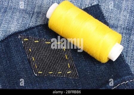 Rhomb-shaped patch on jeans with threads closeup Stock Photo