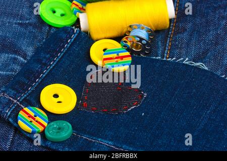 Heart-shaped patch on jeans with threads and buttons closeup Stock Photo