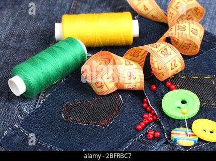 Heart-shaped patch on jeans with threads and buttons closeup Stock Photo