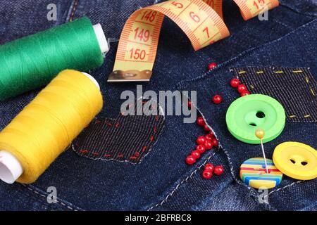 Heart-shaped patch on jeans with threads and buttons closeup Stock Photo