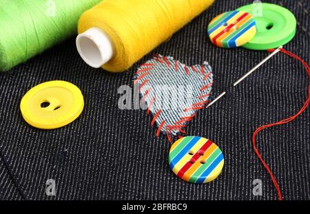 Heart-shaped patch on jeans with threads and buttons closeup Stock Photo