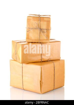 Three parcels wrapped in brown paper tied with twine arranged in stack isolated on white Stock Photo