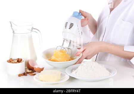 Female hands mixing eggs in bowl isolated on white Stock Photo