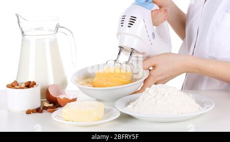 Female hands mixing eggs in bowl isolated on white Stock Photo