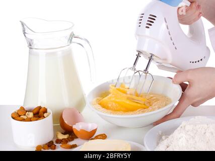 Female hands mixing eggs in bowl isolated on white Stock Photo
