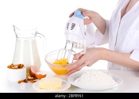 Female hands mixing eggs in bowl isolated on white Stock Photo