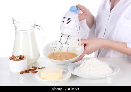Female hands mixing eggs in bowl isolated on white Stock Photo