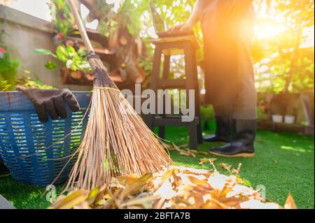 Cleaning and sweep leave at home garden. Stay home Stay safe. Effect from Covid-19 and stop outbreak virus. WFH : Work from home. Stock Photo