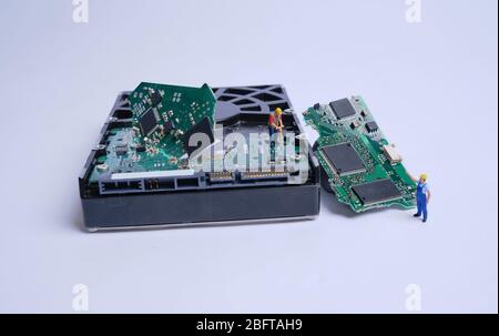 Model figures work on a broken hard drive, white background and copy space Stock Photo