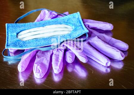 Close-up image of N-95 mask and nitrile disposable gloves on a steel surface