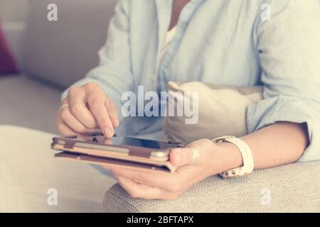 Close-up of woman's hands holding tablet PC and a stylus pen Stock Photo