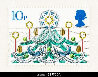 SEATTLE WASHINGTON - April 18, 2020: Close up of 1980 Christmas Stamp of Great Britain, featuring decorated Christmas tree and blue Queen silhouette. Stock Photo