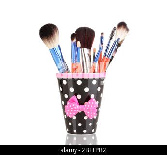 Makeup brushes in a black polka-dot cup isolated on white Stock Photo