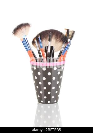 Makeup brushes in a black polka-dot cup isolated on white Stock Photo