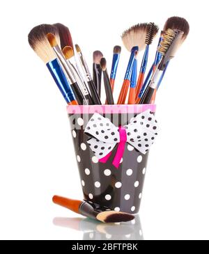 Makeup brushes in a black polka-dot cup isolated on white Stock Photo