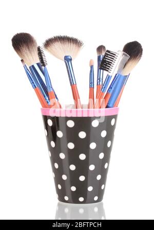 Makeup brushes in a black polka-dot cup isolated on white Stock Photo