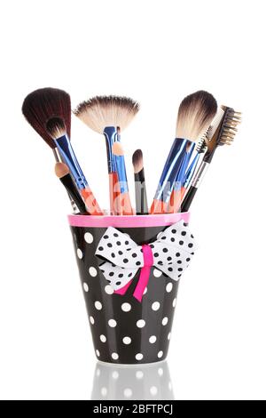 Makeup brushes in a black polka-dot cup isolated on white Stock Photo