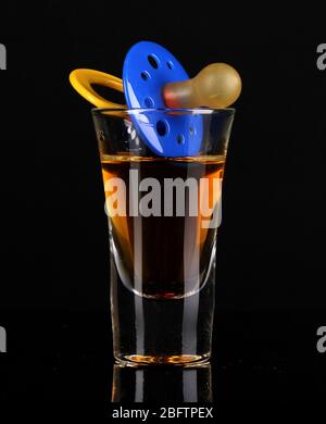 Baby dummy with alcoholic beverage isolated on black Stock Photo