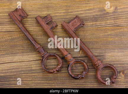 Three antique keys on wooden background Stock Photo