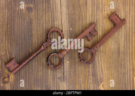 Three antique keys on wooden background Stock Photo