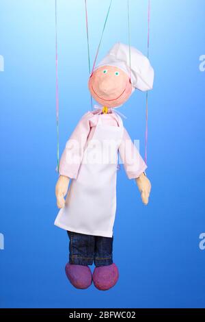 Wooden puppet as cook on blue background Stock Photo - Alamy