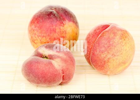 ripe peaches on bamboo mat Stock Photo
