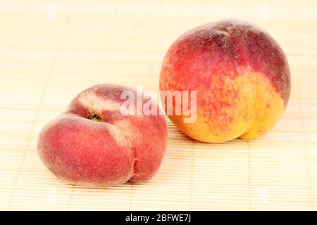 ripe peaches on bamboo mat Stock Photo