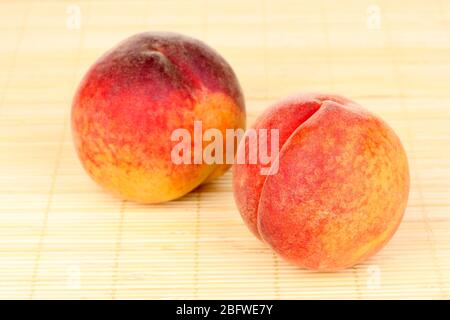 ripe peaches on bamboo mat Stock Photo