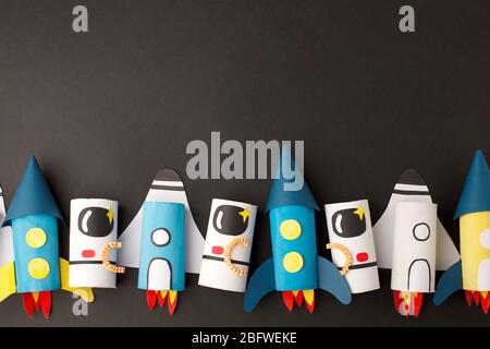 School kindergarten crafts, paper spaceship, shuttle, astronaut on black background with copy space for text. Party concept handcraft, diy, creative i Stock Photo