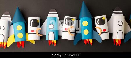 School kindergarten crafts, paper spaceship, shuttle, astronaut on black background with copy space for text. Party concept handcraft, diy, creative i Stock Photo