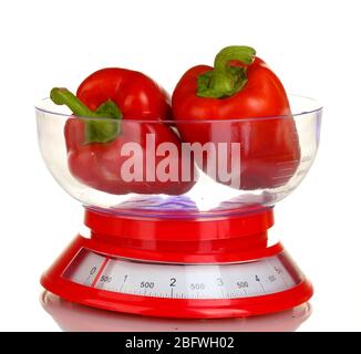 fresh red peppers in a kitchen scales isolated on white Stock Photo