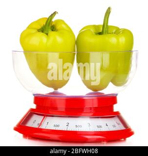 fresh green peppers in a kitchen scales isolated on white Stock Photo