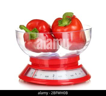 fresh red peppers in a kitchen scales isolated on white Stock Photo