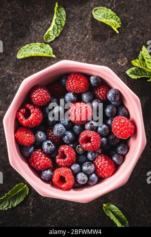 Berry fruit. Raspberries and blueberries in bowl. Top view. Stock Photo