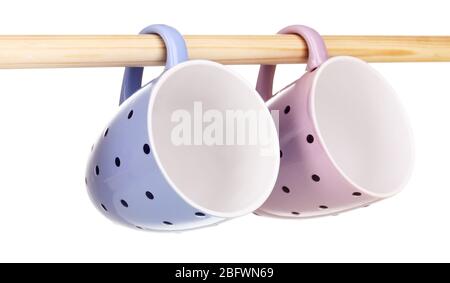 Nice cups hanging on stick isolated on white Stock Photo
