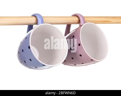 Nice cups hanging on stick isolated on white Stock Photo