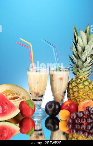 Milk shakes with fruit on blue background close-up Stock Photo