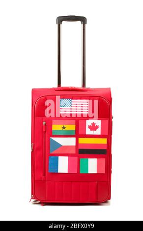 red suitcase with many stickers with flags of different countries isolated on white Stock Photo