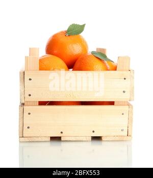 Ripe tasty tangerines with leaves in wooden box isolated on white Stock Photo