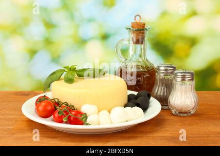 cheese mozzarella with vegetables in the plate on wooden table close-up Stock Photo