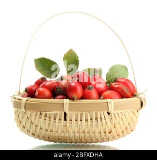 ripe hip roses with leaves in basket, isolated on white Stock Photo