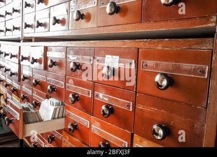 Old directory with many wooden index drawers. Vintage file catalog box ...